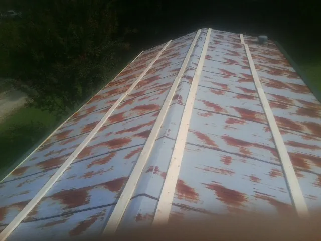 Rusted metal roof panels with new wood purlins before replacement — Storm Damage Roof Repair in Green by Roofing Brothers